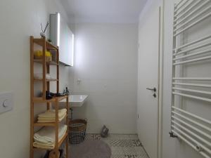 a bathroom with a sink and a shelf with towels at ONE Apartment in Braşov