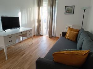 uma sala de estar com um sofá e uma secretária com uma televisão em Apartment Split Downtown em Split