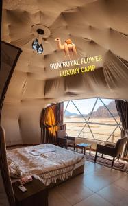 Cette chambre dispose d'un lit et d'un panneau indiquant la présence d'un camp de luxe de fleurs thyroïdes. dans l'établissement RUM ROYAL FLOWER lUXURY CAMP, à Wadi Rum