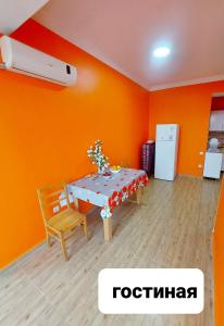 uma sala de jantar com paredes cor de laranja e uma mesa e cadeiras em Riviera Kobuleti em Kobuleti