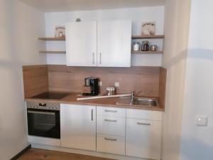 a kitchen with white cabinets and a sink at Ferienwohnung Gipfelblick in Freyung