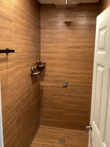 a bathroom with a shower with wooden walls at Secret Garden in Cahuita