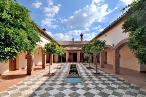 a courtyard with trees in the middle of a building at Finca La Fronda in Alájar