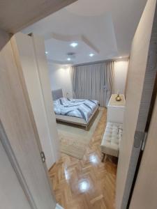 a small bedroom with a bed and a mirror at Matej LUX Apartment in Skopje