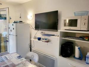 een keuken met een witte koelkast en een magnetron bij Gîte VILLA Nautica Résidence Cap Soleil in Vendres