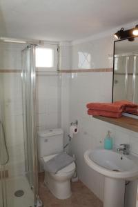 a white bathroom with a toilet and a sink at FERRUM house in Hanioti +50 photos