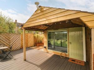a wooden deck with awning and a patio at Langdale Lodge in Okehampton