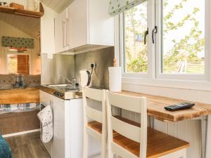 a kitchen with white cabinets and a counter with a window at Langdale Lodge in Okehampton