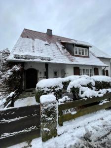 een huis met een met sneeuw bedekt dak bij Wohnung am Bergpark Wilhelmshöhe in Kassel