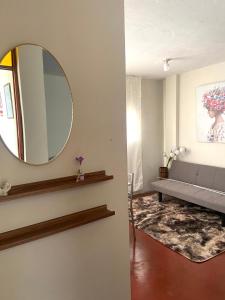 ein Wohnzimmer mit einem Spiegel und einem Sofa in der Unterkunft airbnb lima farfalla in Lima