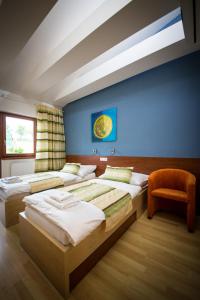 a bedroom with four beds and a blue wall at Penzion Proneco in Klentnice