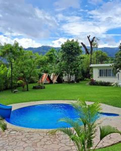 a blue swimming pool in a yard with a house at Villas El Amatle 