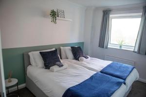 a bedroom with a large bed with two pillows at Charming 2-Bed Apartment Free Parking in Wimbledon in London