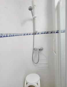 een witte badkamer met een douche en een toilet bij Gîte VILLA Nautica Résidence Cap Soleil in Vendres