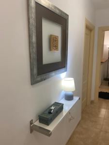 una mesa con una lámpara y una foto en la pared en Apartamento Santa Clara Centro, en Antequera