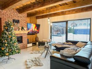 a living room with a christmas tree and a couch at Wellness Chalet in Mýto pod Ďumbierom