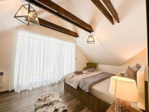 a bedroom with a bed and a large window at Wellness Chalet in Mýto pod Ďumbierom