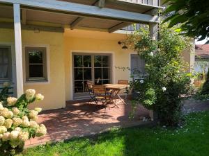 a patio with a table and chairs in a yard at Chiemsee Beachhouse Apartment in Bernau am Chiemsee