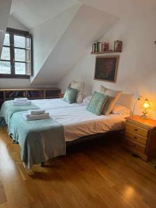 ein Schlafzimmer mit einem großen Bett im Dachgeschoss in der Unterkunft Ático B Residencial Caldares El Pueyo in El Pueyo de Jaca
