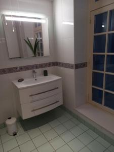 a white bathroom with a sink and a mirror at le Fort de Bayle in Sedan