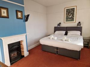 a bedroom with a bed and a fireplace at Railway Hotel in Faversham