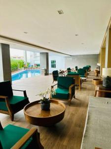 a waiting room with green chairs and a pool at Makati Staycation by Marco - SMDC Lush in Manila
