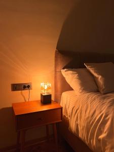 Una cama con una mesita de noche con una vela. en Terazije Center Apartments, en Belgrado