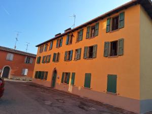 ゾーラ・プレドーザにあるAppartamento MANARAの緑のドアと窓のあるオレンジ色の建物