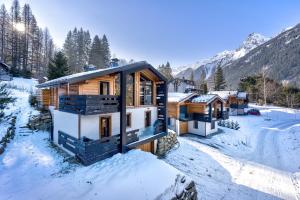 drewniany dom w śniegu w górach w obiekcie Chalet Green Forest w Chamonix-Mont-Blanc