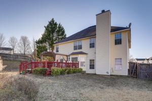 a large white house with a red fence at Pet-Friendly Georgia Escape with Deck, Grill and Yard! in Conyers