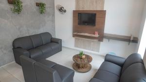 a living room with a couch and a tv at Hotel GranDourados in Dourados