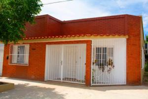 um edifício de tijolos vermelhos com duas portas de garagem brancas em Casa Aconchego em Paso de los Libres