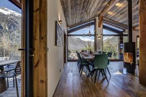 ein Esszimmer mit einem Tisch, Stühlen und Bergen in der Unterkunft Chalet Green Forest in Chamonix-Mont-Blanc