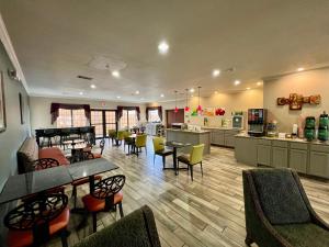 a restaurant with tables and chairs and a kitchen at Quality Inn & Suites Near University in Waco