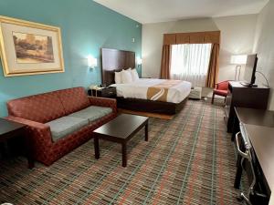 um quarto de hotel com uma cama e um sofá em Quality Inn & Suites Near University em Waco