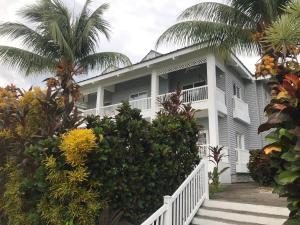 una gran casa blanca con palmeras delante en The Sanctuary Condominium Playa Azul 6, en Playa Azul