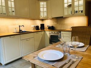 a kitchen with a table with plates and wine glasses at Chiemsee Beachhouse Apartment in Bernau am Chiemsee