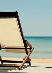 uma cadeira na praia com o oceano ao fundo em Cave Beach House Milos em Provatas