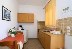 a small kitchen with a table and a sink at Aleka apartment 2 in Agios Georgios +8 photos