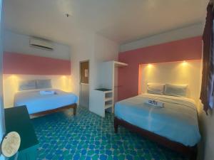 - 2 lits dans une chambre rouge et blanche dans l'établissement Hotel Casa Cactus HCC, à Chachalacas