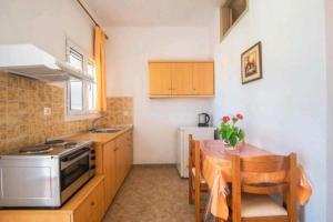 a kitchen with a table and a stove and a sink at Aleka apartment 2 in Agios Georgios