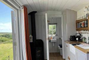 a kitchen with a sink and a toilet and a window at The Daffodil Hut in Porkellis