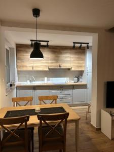 a kitchen with a wooden table and chairs and a table and a kitchen with at Kasi Polany in Krempna