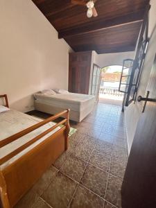 - une chambre avec 2 lits et un ventilateur de plafond dans l'établissement Casa com piscina em Barra do Una, à São Sebastião