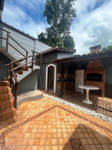 une terrasse avec un escalier et une table en face d'une maison dans l'établissement Casa com piscina em Barra do Una, à São Sebastião