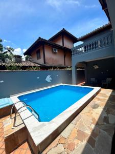 a swimming pool in front of a house at Casa com piscina em Barra do Una in São Sebastião