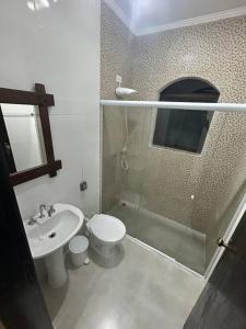ein Bad mit einem Waschbecken, einem WC und einer Dusche in der Unterkunft Casa com piscina em Barra do Una in São Sebastião