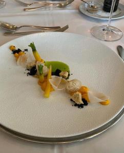 a white plate with vegetables on a table at Grandhotel Lienz Business-Wellness & Gourmet in Lienz