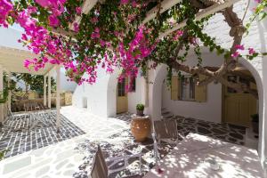 une terrasse avec un arbre et des fleurs roses dans l'établissement Rocco's studios, à Antiparos