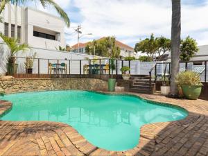 a swimming pool in the middle of a yard with a fence at Neighbourgood Ravenscraig in Cape Town